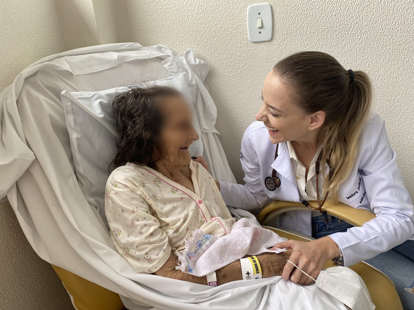 Dra. Isadora conversando com uma paciente idosa